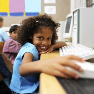 Young Girl at School Holding a Computer Mouse